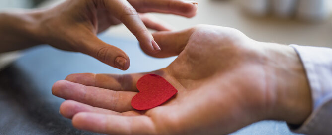 Uomo che dona un cuore rosso ad una donna