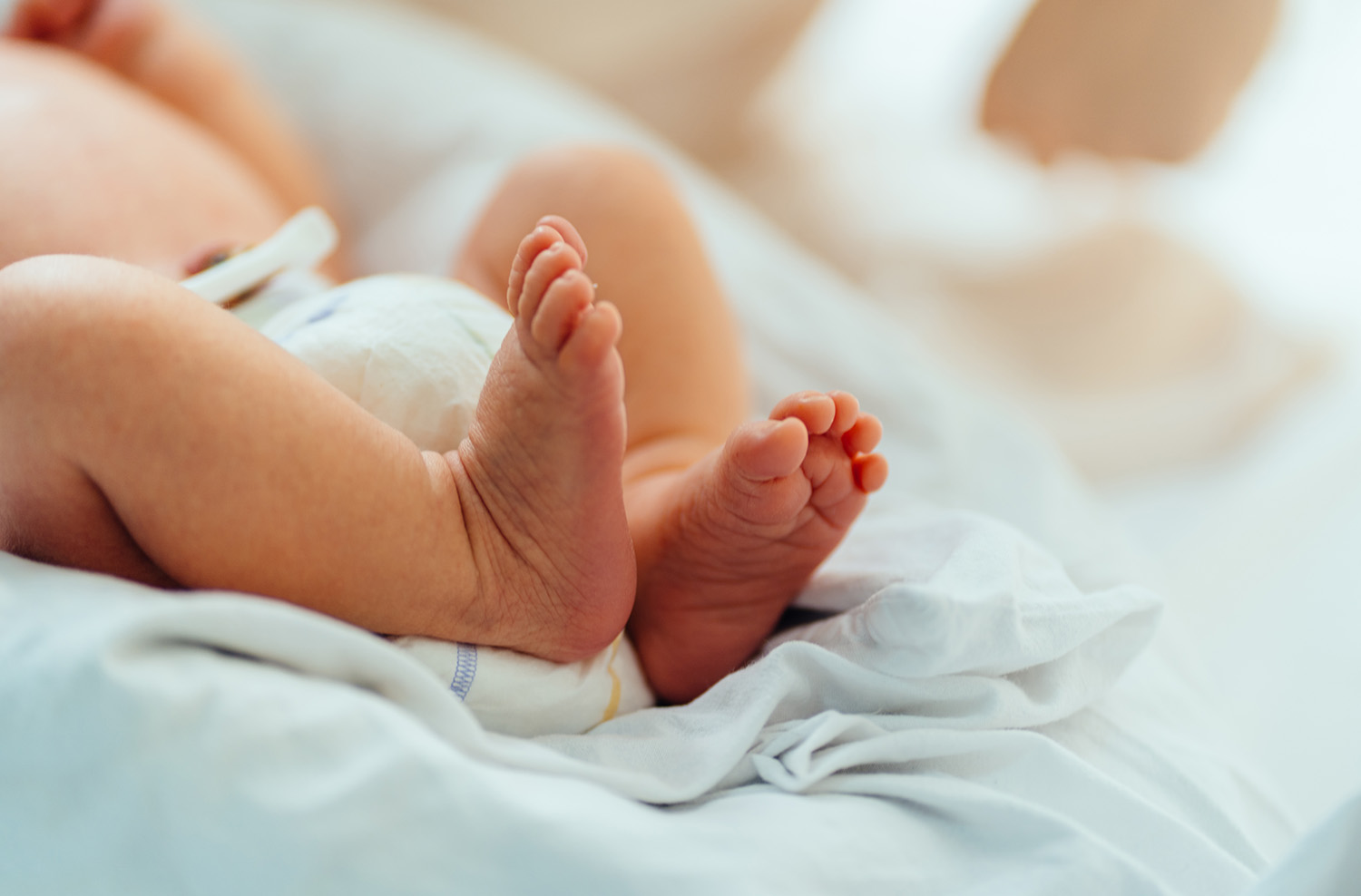 Piedini di neonato su una coperta bianca in ospedale