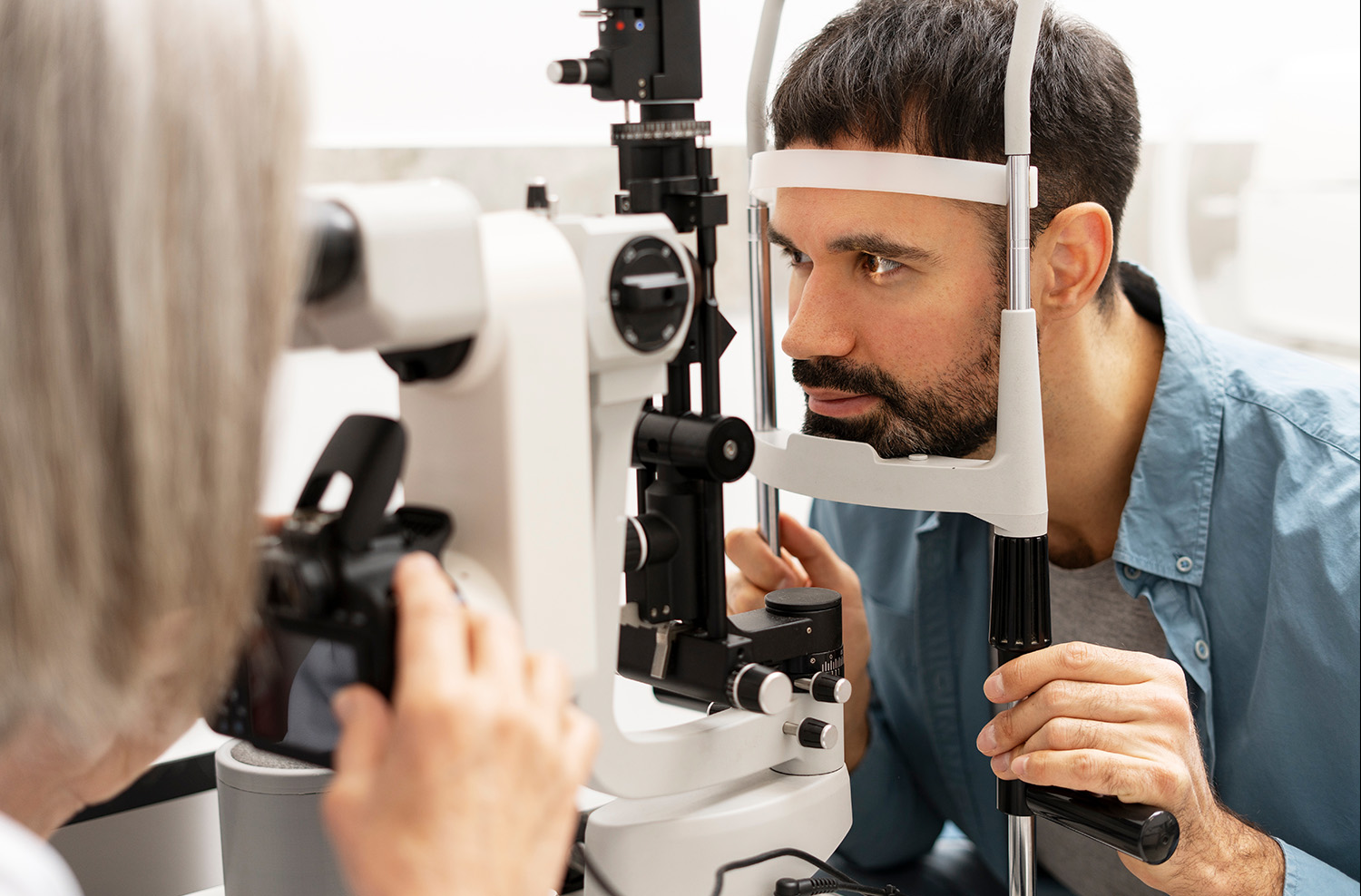 Ooculista utilizza una fotocamera digitale collegata a una lampada a fessura per scattare immagini dettagliate dell'occhio del paziente durante un esame oculistico completo